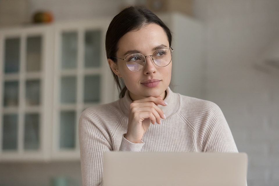 Woman wearing glasses looking at laptop
